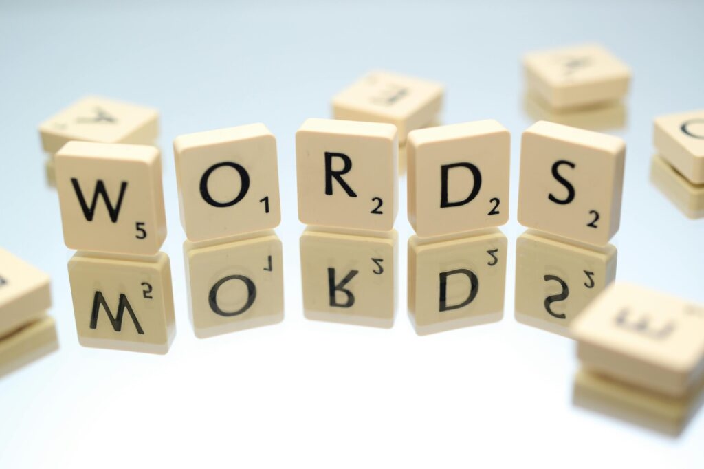 pexels-photo-695571-695571 Scrabble tiles spelling 'words' on glass reflecting surface, perfect for language and games themes.