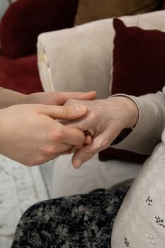 pexels-photo-36706840-36706840 A close-up of two hands showing support and care, symbolizing generational connection indoors.